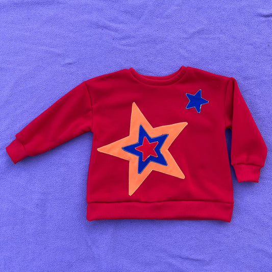 Red sweatshirt with star design on a purple background