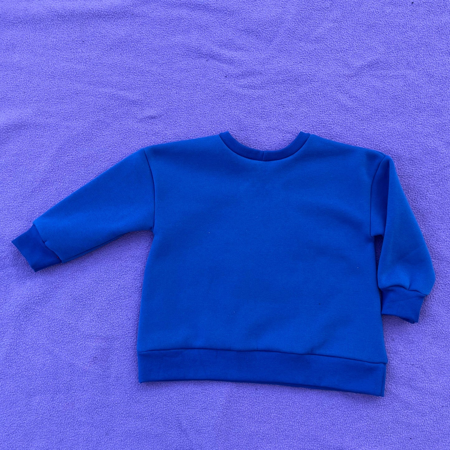 Blue sweatshirt on purple background