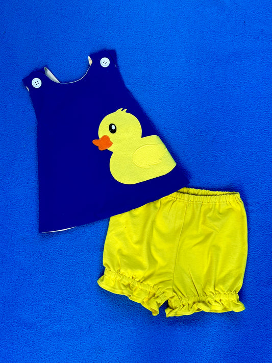 Children's blue dress with yellow duck design and matching yellow bloomers on a blue background
