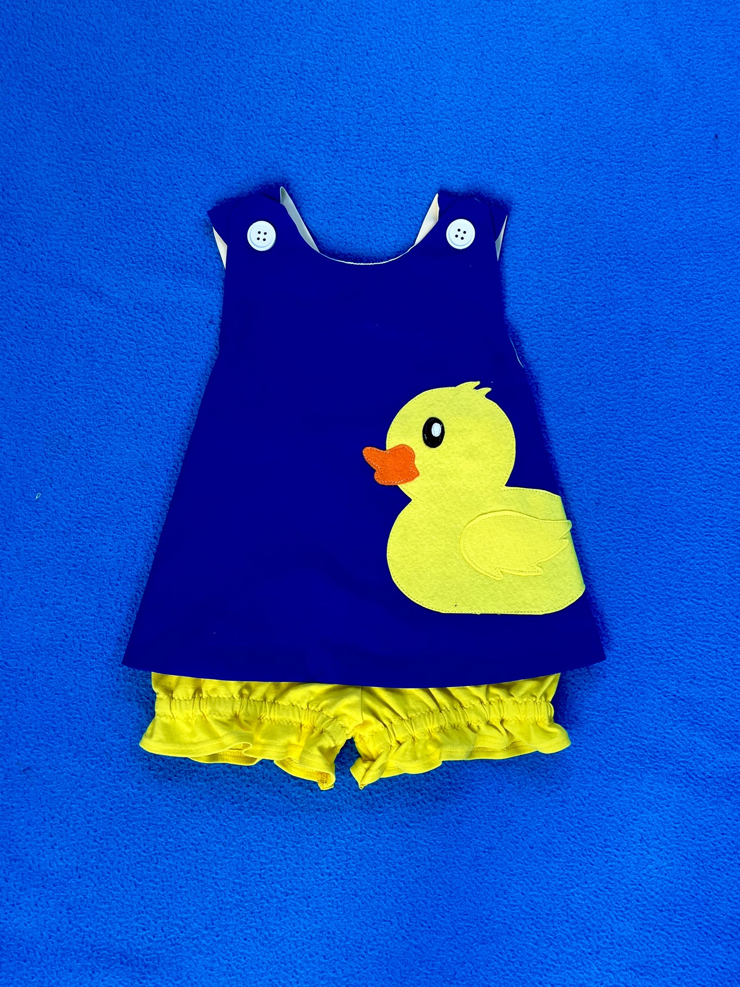 Navy blue dress with yellow duck design on a blue background